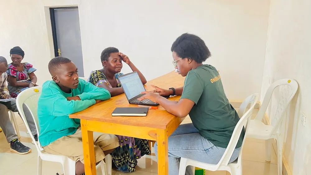 A team member recording community baseline information on a laptop